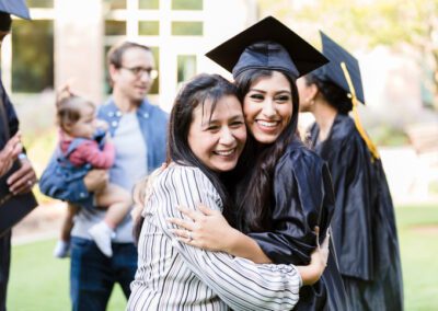 Mother and graduating daughter pose cheek to cheek for photo