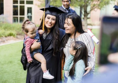 Unrecognizable person takes photo of multi-generation family at graduation